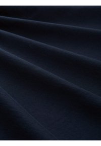 Tissu bleu marine foncé avec une texture lisse, présentant un drapé subtil et une apparence uniforme, sans motifs ou accents distincts.