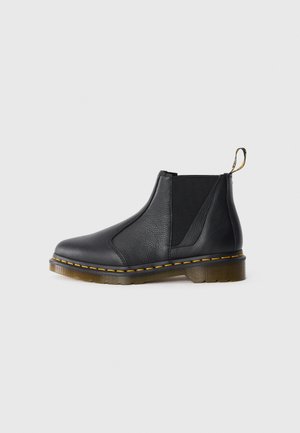 Zwarte leren enkelboots met elastische zijpanelen, ronde neus, contrasterende gele stiksels en een gestructureerde zool voor grip.