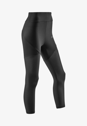 Leggings neri a vita alta con una finitura liscia e pannelli in rete testurizzati sulle gambe inferiori, progettati per comfort e flessibilità.