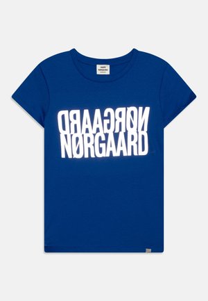 Blaues Kurzarm-T-Shirt mit Rundhalsausschnitt, mit fettem weißem, spiegelverkehrtem "NØRGAARD" Schriftzug auf der Brust und einem kleinen gestreiften Etikett am Saum.