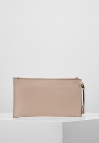 Béžové texturované kožené psaníčko s zlatým zipem a malým poutkem na bílém povrchu.