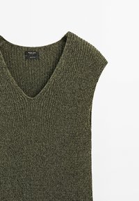 Gilet sans manches tricoté vert olive avec col en V et texture côtelée, en 100 % coton par Massimo Dutti.