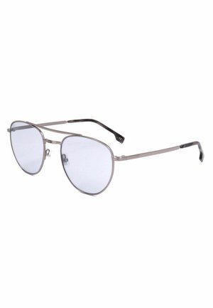Un paio di occhiali da sole aviator in metallo argento con sottili montature e lenti sfumate grigio chiaro, inclinati su uno sfondo bianco.