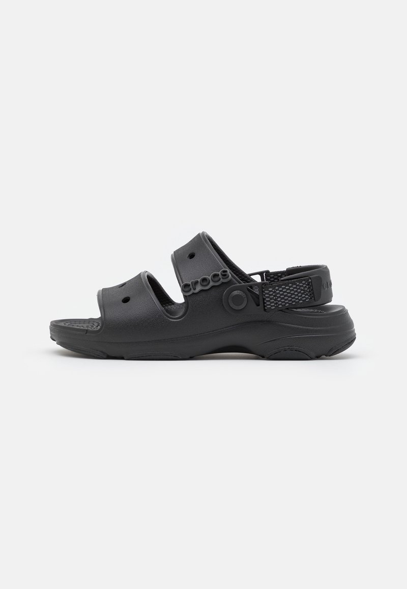 Sandales Crocs noires avec deux sangles réglables, semelle intérieure texturée et sangle au talon arrière. Fabriquées en matériau léger et durable.