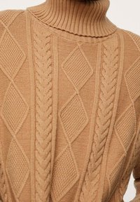 Beige gestrickter Pullover mit hohem Rippsaumkragen, strukturierten Rautenmuster und Zopfmustern sowie einer gemütlichen, dicken Textur.