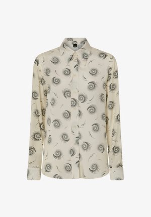 Kremasta bluzica s crnim kružnim uzorcima spirala. Dugi rukavi, klasični ovratnik, kopčanje sprijeda na dugmad i ravni rub s detaljima na manžetama.