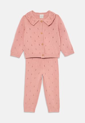 Rosa strikket to-dels sett med en knapp-up cardigan med en bølgete krage, og matchende leggings med et diamantmønster.