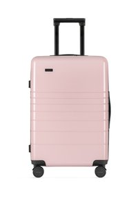 Hartschalenkoffer in Pink mit vertikalen Rillen, ausziehbarem schwarzen Griff und vier robusten Rollen. Kompaktes und leichtes Design.