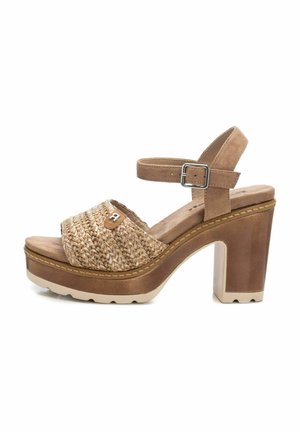 Sandalo con platform e tomaia in paglia intrecciata, cinturino alla caviglia in suede beige e tacco spesso. Presenta una superficie testurizzata e cuciture a contrasto.