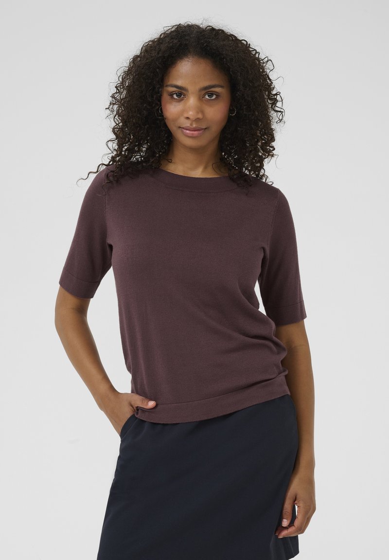 Korte ærmer, rundhalset sweater i dyb lilla strikstof, med en afslappet pasform og diskrete ribkanter langs halsudskæringen og kanten.