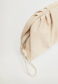 Pochette en simili cuir beige avec un design plissé, une fermeture éclair et une poignée décorative en boucle. Texture lisse, style minimaliste.