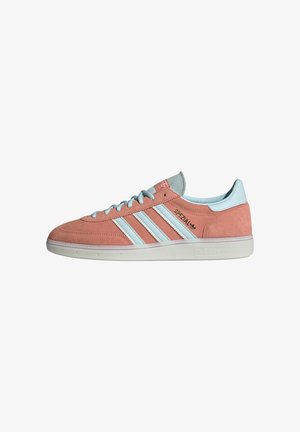 Baskets basses roses en daim Adidas Spezial avec bandes bleu clair, lacets, languette au talon et semelle en caoutchouc blanche.