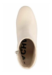 Boots chelsea crème avec un extérieur en cuir lisse, bout arrondi et détail de fermeture éclair argentée. L'intérieur dispose d'un rembourrage doux avec imprimé logo.
