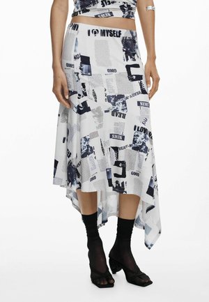 Asymmetrical skirt in white fabric, featuring a collage of black and navy prints, with text and images. Paired with black socks and heeled sandals.