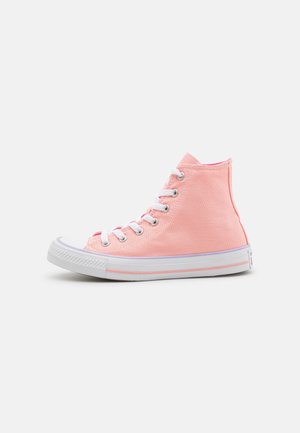 Baskets montantes en toile rose clair avec semelle en caoutchouc blanc et lacets blancs, présentées de côté sur fond blanc.