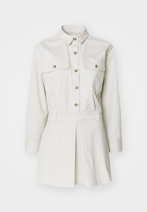 Λευκό βαμβακερό φόρεμα πουκαμίσα με μακριά μανίκια, κολάρο, δύο τσέπες στο στήθος και λεπτομέρεια πτυχών στη φούστα, με κλείσιμο από κουμπιά.