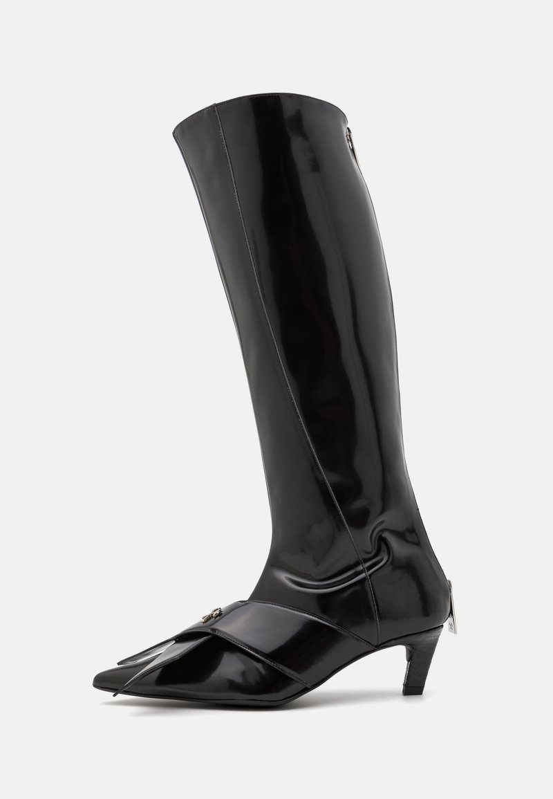 Schwarze kniehohe Stiefel aus glänzendem Material, mit spitzem Zehenbereich, einem kleinen Absatz und einem seitlichen Reißverschluss mit dekorativem Riemen.