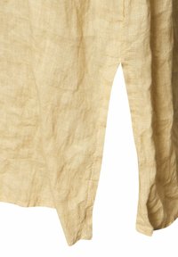 Linnetyg plagg i ljusbeige med en strukturerad yta. Har en sidoklyvning och rå fåll för extra detalj. Mjuk, andningsbar tyg.