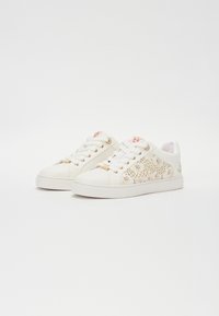 Sneakers bianchi con dettagli in pizzo floreale dorato, punta rotonda, suola piatta e occhielli color oro. Sottotoni rosa delicati all'interno della linguetta.