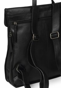 Mochila de cuero negra con correas ajustables dobles, múltiples bolsillos con cremallera y textura suave. Incluye acentos de hardware en tono plateado.