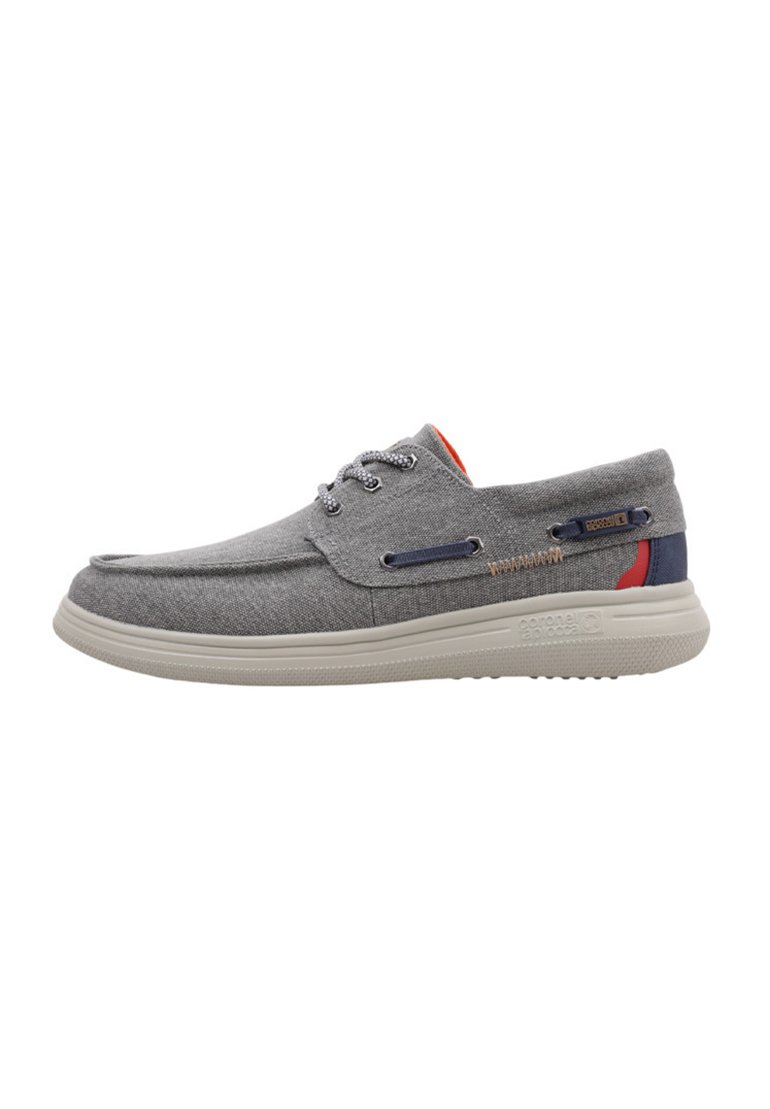 Zapatos náuticos de tela gris con puntera redondeada, detalles en azul marino y rojo, ojales plateados y una suela texturizada. Diseño de cordones para un ajuste seguro.