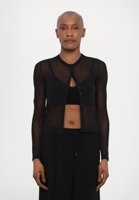 Black sheer cardigan with long sleeves, button closure, and a fitted silhouette, layered over a black top. Smooth texture, minimalist design.