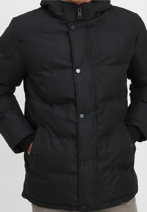 Black puffer jacket with a hood, featuring a zip closure, snap buttons, and side pockets. Material is textured and thick, providing warmth.