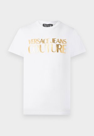 Valge lühikeste varrukatega T-särk, mille esiküljel on kuldse metallikuga kiri "Versace Jeans Couture" ja ümara kaelusega.