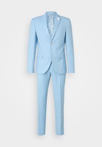 Light blue suit made of smooth fabric. The jacket has a single button and a floral pin. Pants are tailored with a straight cut.