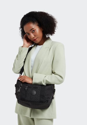 Black shoulder bag with a textured pattern, zippered pockets, and logo detail. The material appears durable and lightweight.