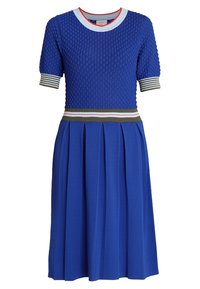 Robe bleue avec de courtes manches texturées, un col côtelé et une jupe plissée. Elle présente une ceinture rayée avec des accents verts, blancs et rouges.