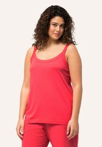 Red sleeveless top made of soft fabric with a scoop neckline and wide straps, featuring a relaxed fit. No visible patterns or hardware.