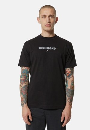 Maglietta in cotone nera con testo "RICHMOND" in bianco, caratterizzato da un font audace. Maniche corte e scollatura a girocollo classica.