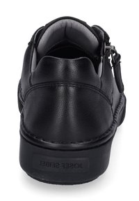 Scarpa in pelle nera con superficie texturizzata, tacco rotondo, colletto imbottito e zip laterale. Dettagli di cucitura sottile lungo la base.