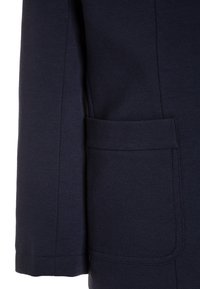 Námořnická modrá bunda z měkkého materiálu s elegantním designem. Obsahuje boční kapsu a pečlivě prošívané švy.