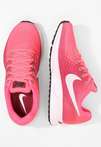Scarpe da corsa Nike rosa con tomaia in mesh traspirante, design testurizzato, chiusura con lacci e logo swoosh bianco. Suola in gomma per un'ottima aderenza.