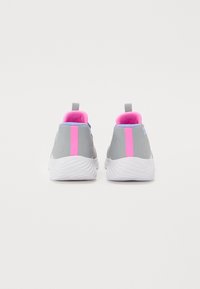 Zapatillas grises con un acento en rosa y azul; la vista trasera resalta una franja rosa contrastante y una suela blanca texturizada.