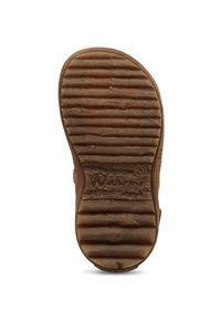 Hnědá gumová podrážka boty s texturovanými drážkami, má kulatou špičku a otisk loga. Povrch vypadá opotřebovaně s výraznými vzory opotřebení.