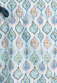 Tela azul clara con un patrón repetido de formas de lágrima en varios colores, con diseños florales y contornos sutiles.