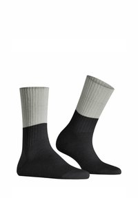 Schwarze und graue Baumwollsocken mit einem gerippten Design. Der obere Bereich ist hellgrau und verläuft zu schwarz im Knöchel- und Fußbereich.