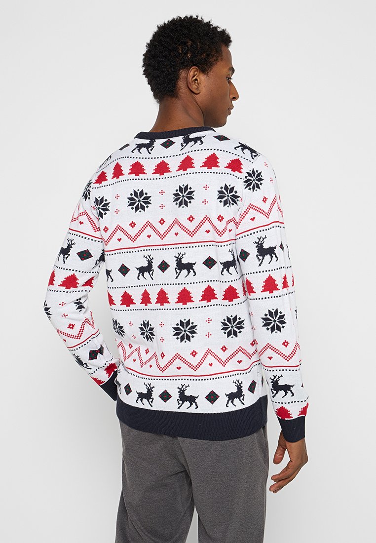 Biały sweter z czarnymi reniferami, czerwonymi drzewami i wzorami płatków śniegu. Żebrowane granatowe mankiety i dół. Wykonany z materiału teksturowanego.