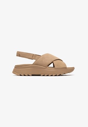 Beige Wildleder-Sandalen mit Kreuzriemen-Design, offenem Zehenbereich, hinten mit Slingback und einer strukturierten Gummisohle mit Zickzackmuster.