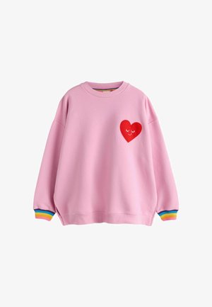 Felpa rosa a maniche lunghe con toppa a forma di cuore rosso sul petto, raffigurante occhi chiusi e un sorriso, e polsini a righe arcobaleno ai polsi.