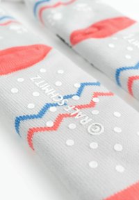 Calzini grigi con motivi zigzag rossi e blu, pois bianchi e materiale testurizzato. Marchio visibile in bianco lungo il lato.