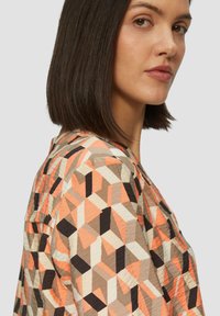 Kraagoverhemd in een geometrisch patroon met oranje, beige en zwarte kleuren. Lichtgewicht stof met een gladde textuur en een relaxte pasvorm.