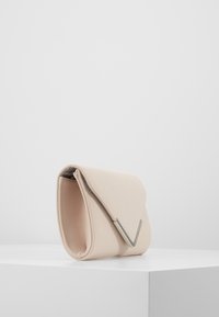 Pochette in pelle beige con patta piegata e accentuazione metallica a forma di V. La superficie testurizzata e i bordi arrotondati creano un design elegante.