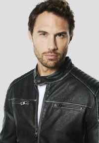 Zwarte leren motorjas met een kraag, ritssluitingen op de zakken en gewatteerde schouderaccenten. Getextureerd oppervlak met een merklogo.