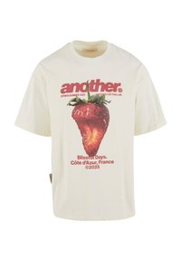Cremfarbendes Baumwoll-T-Shirt mit einem großen Erdbeer-Graphic und rotem Text, der "another", "Blissful Days" und "Côte d'Azur, Frankreich" liest.