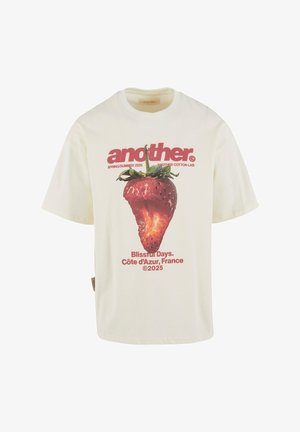 T-shirt in cotone crema con una grande grafica di fragole e testo rosso che recita "un altro," "Giorni Felici," e "Côte d'Azur, Francia."