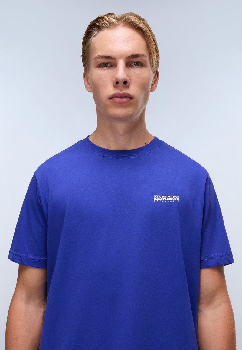 Kongeblå kortærmet t-shirt lavet af bomuld. Har et lille hvidt logo på brystet, rund halsudskæring og en afslappet pasform.